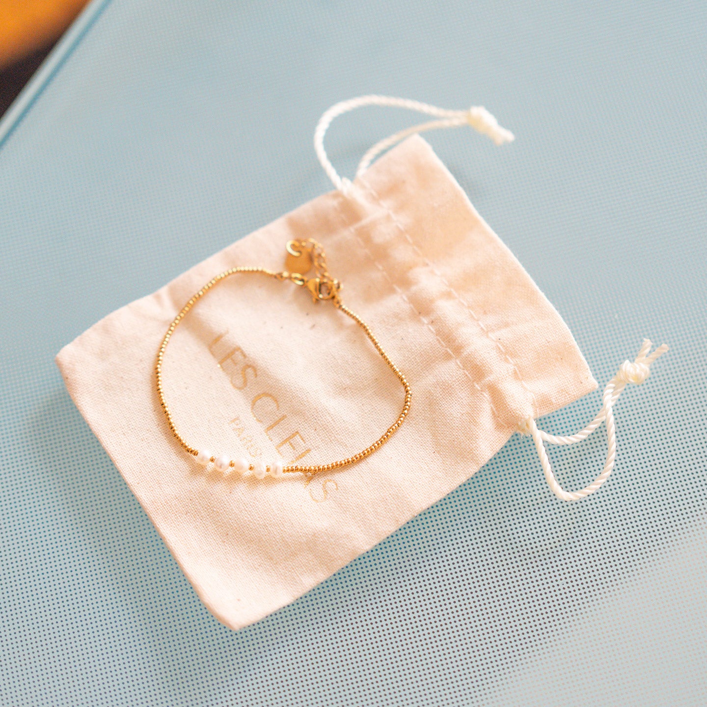 Bracelet en perles blanches avec chaîne dorée délicate