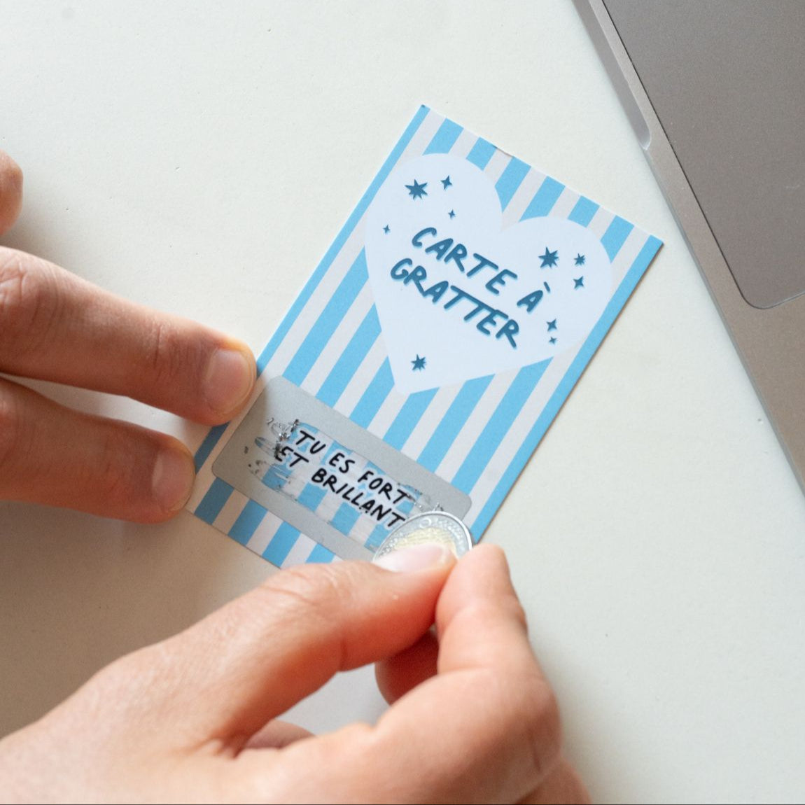Carte à gratter avec message doré sur fond blanc