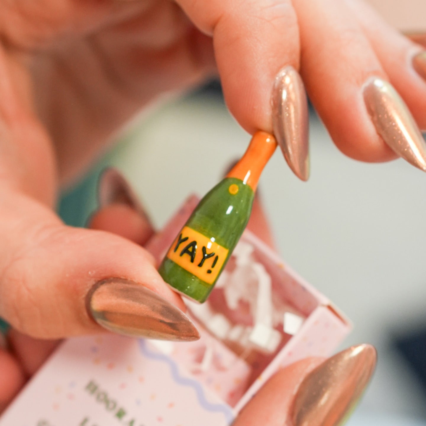 Fève en céramique de champagne dans une boîte colorée