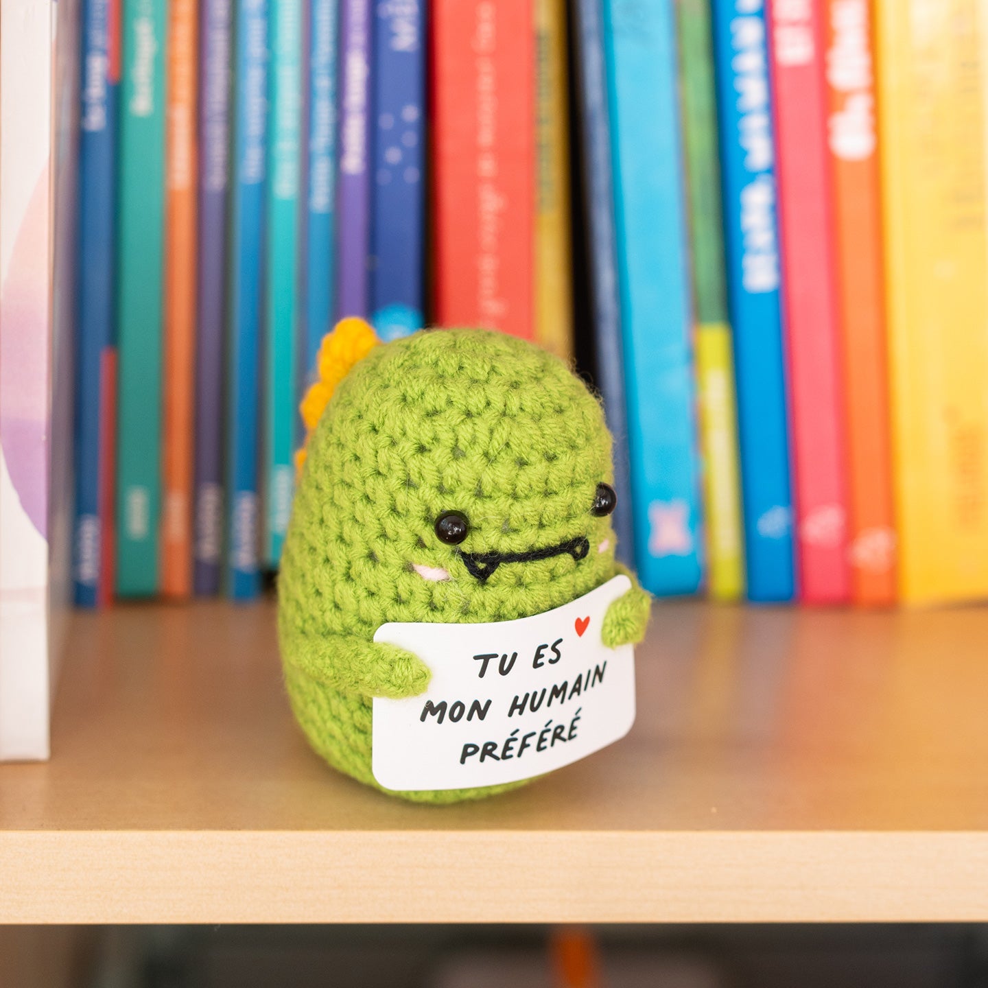Détail du T-Rex en crochet tenant une pancarte affectueuse.