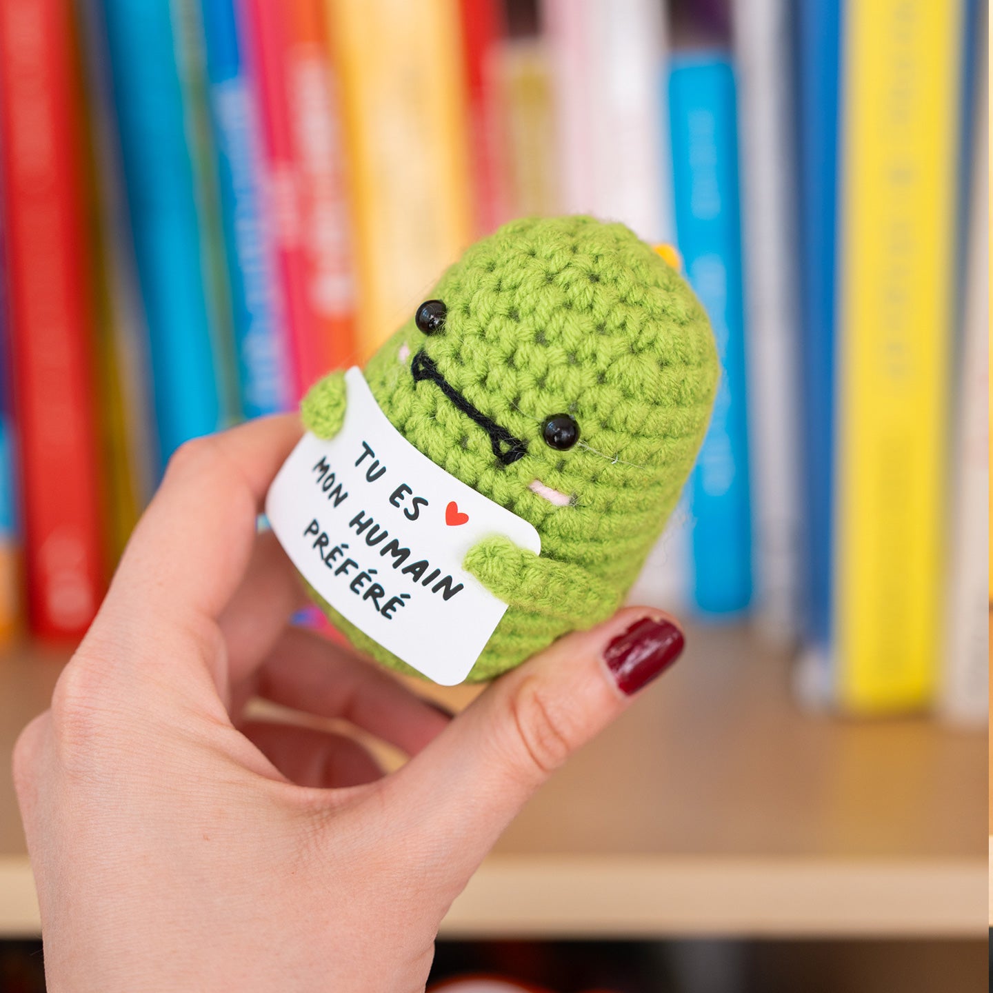 Détail du T-Rex en crochet tenant une pancarte affectueuse.
