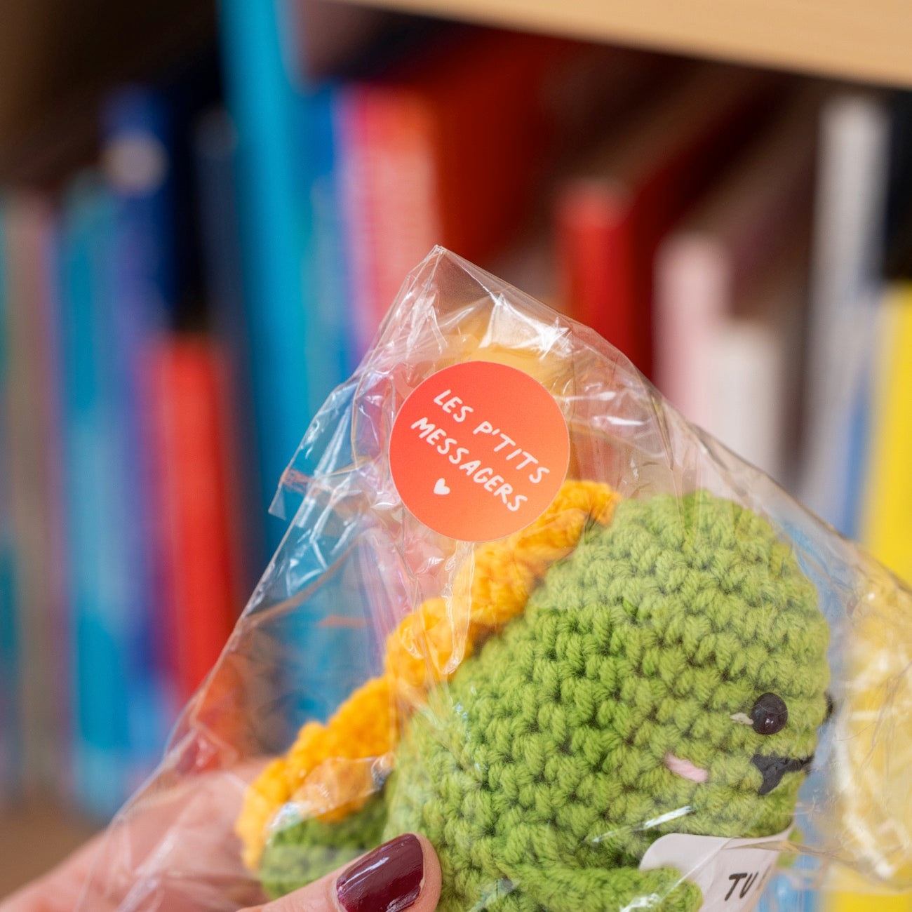 Détail du T-Rex en crochet tenant une pancarte affectueuse.