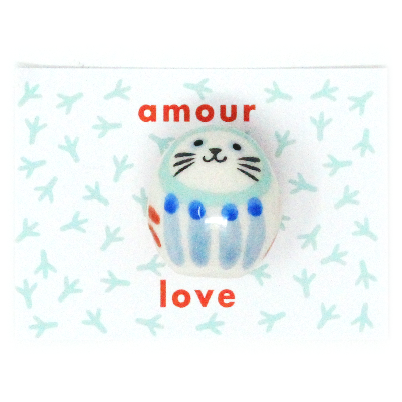 Grigri amour en faïence, motif cœur coloré sur fond clair.