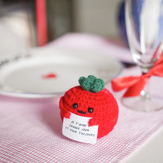 Peluche tomate en crochet avec message d'amour en gros plan.