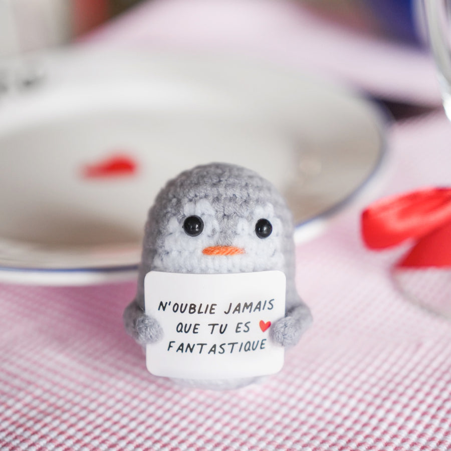 Peluche pingouin en crochet avec message inspirant sur son aile.