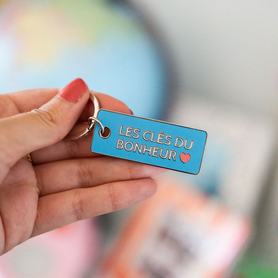Porte-clés en métal avec inscription inspirante sur fond clair.