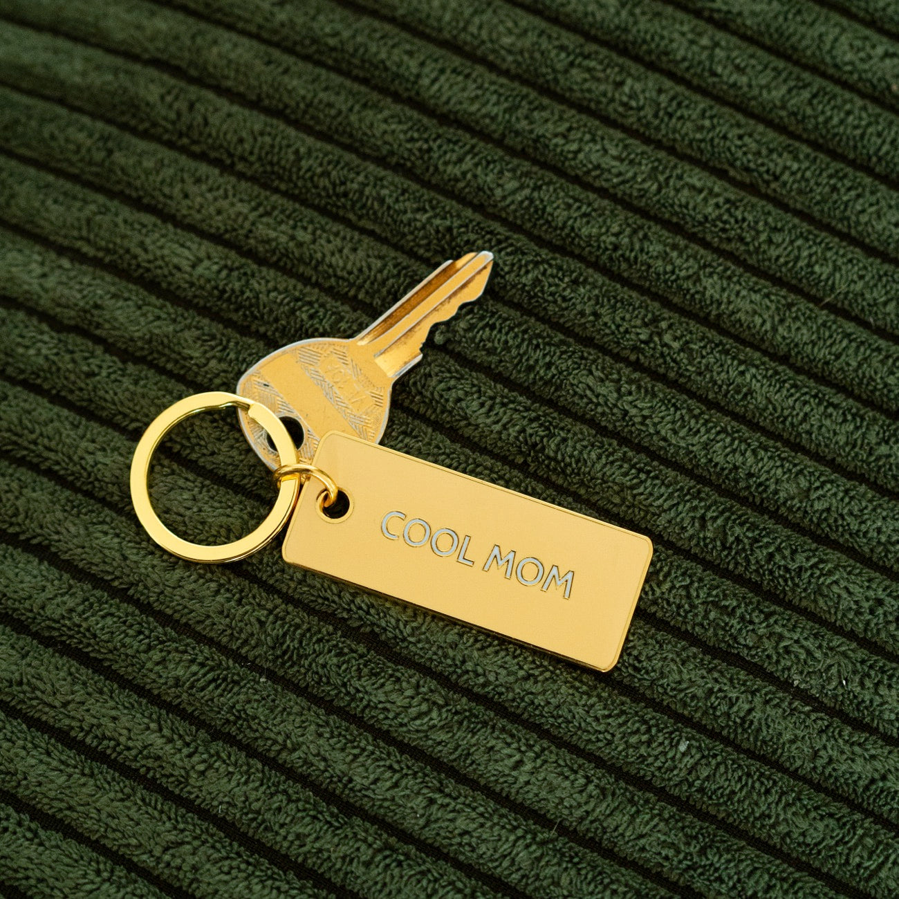 Porte-clé 'Cool Mom' avec inscription en relief sur fond clair.
