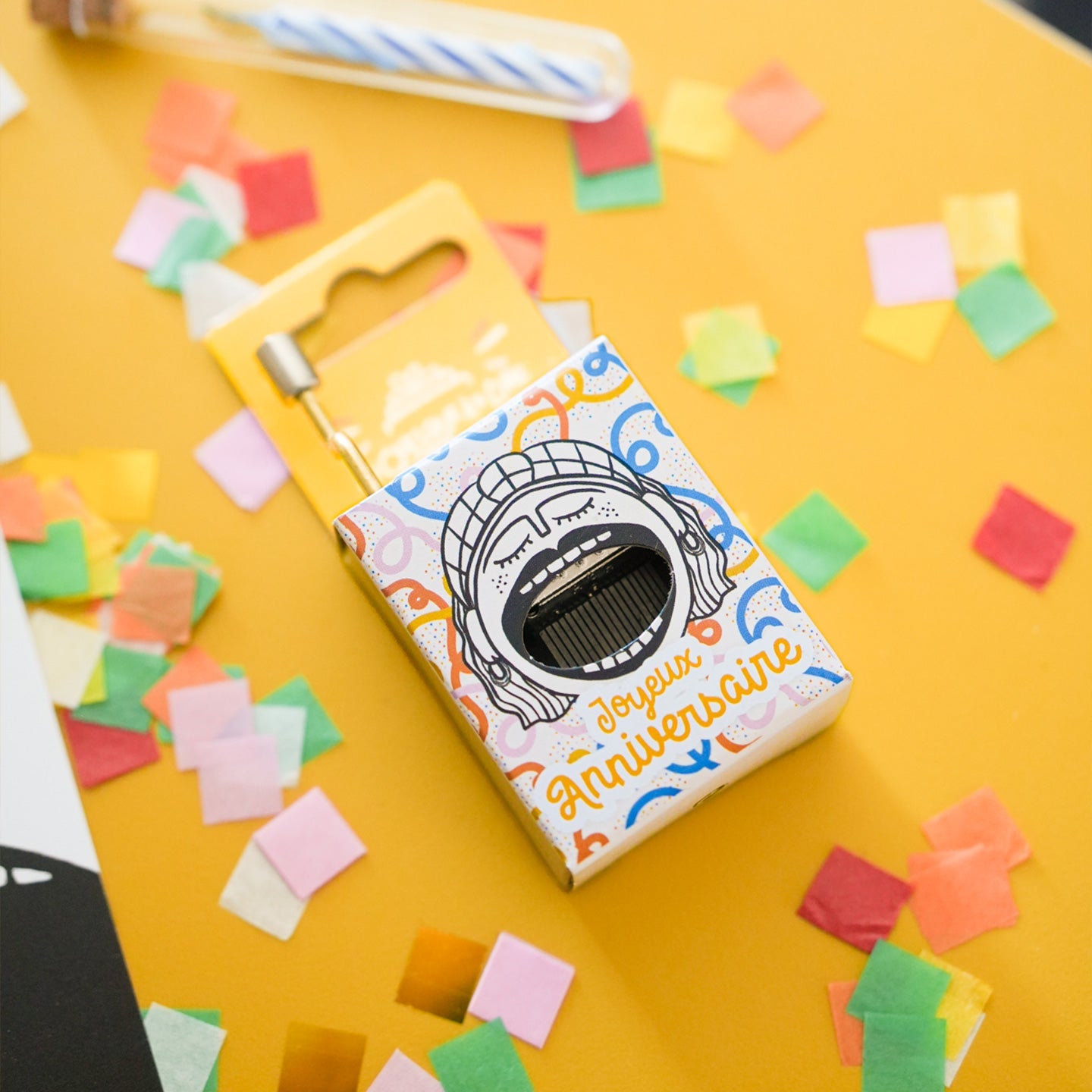 Boîte à musique avec gâteau d'anniversaire et bougies colorées.