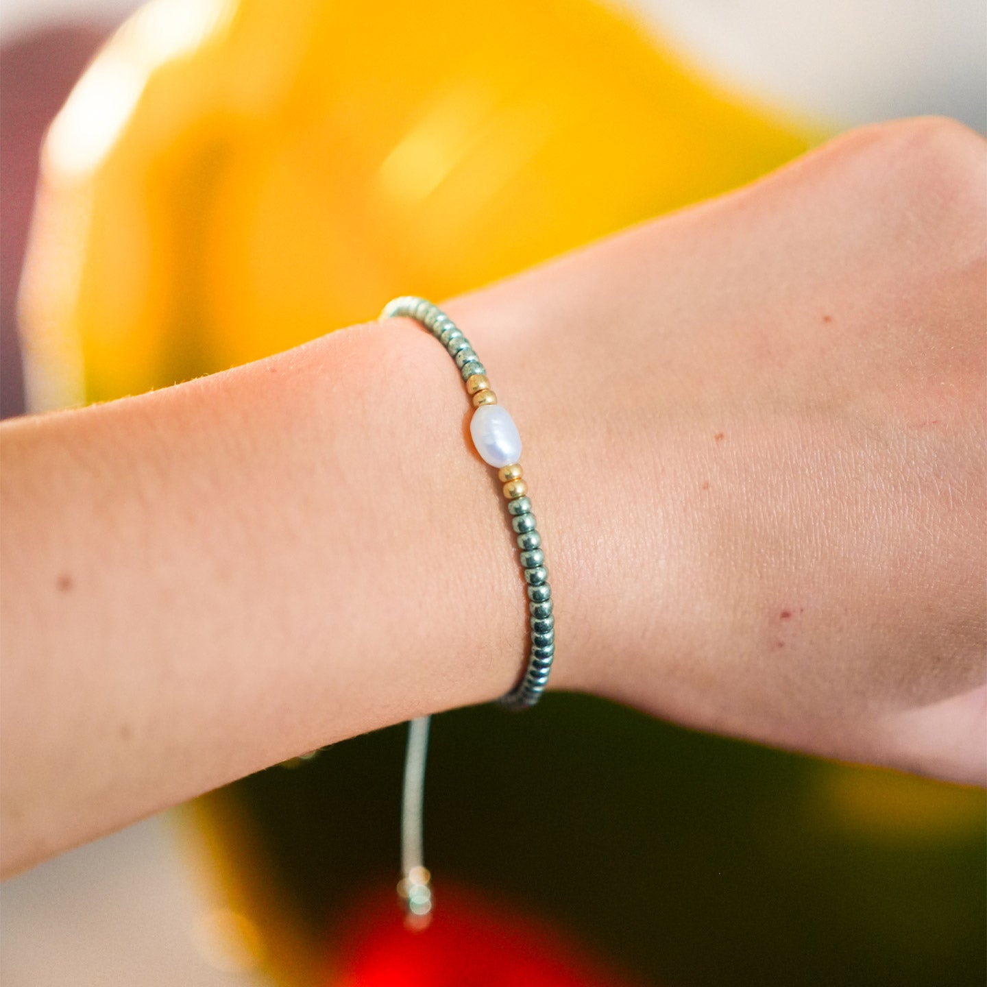 Bracelet en perles d'eau avec reflets verts et dorés