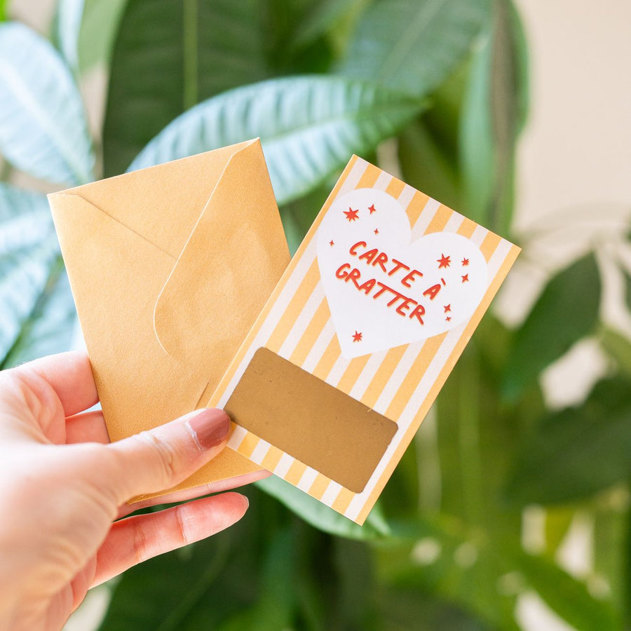 Carte à gratter avec message inspirant sur fond coloré.