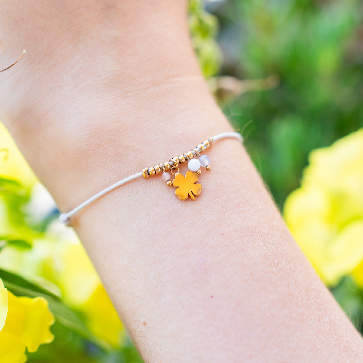 Bracelet avec pendentif trèfle doré sur cordon rose
