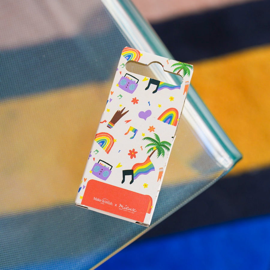 Boîte à musique avec manivelle, motif arc-en-ciel coloré.