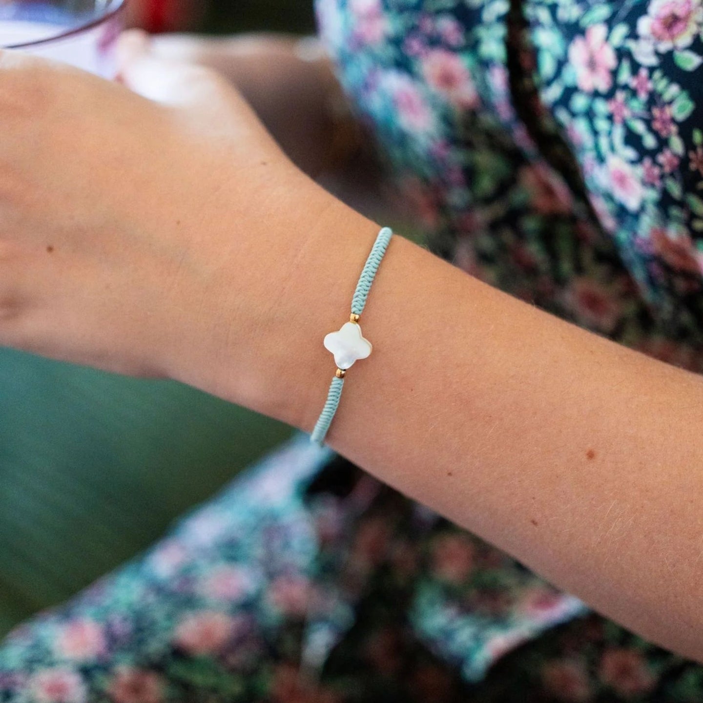 Bracelet tressé vert d'eau avec fleur nacrée et accents dorés