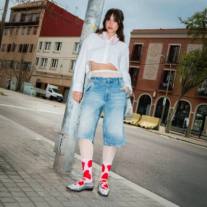 Chaussettes blanches à grands motifs rouges portées avec un jean ample