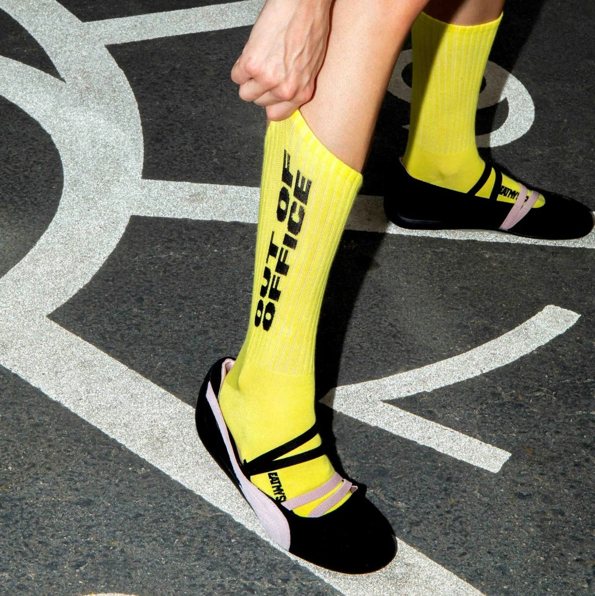 Chaussettes jaune vif à message noir, portées avec des ballerines à brides