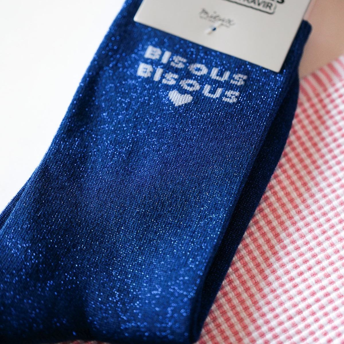 Chaussettes pailletées avec motif bisous sur fond clair.