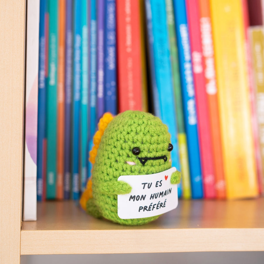 Détail du T-Rex en crochet tenant une pancarte affectueuse.