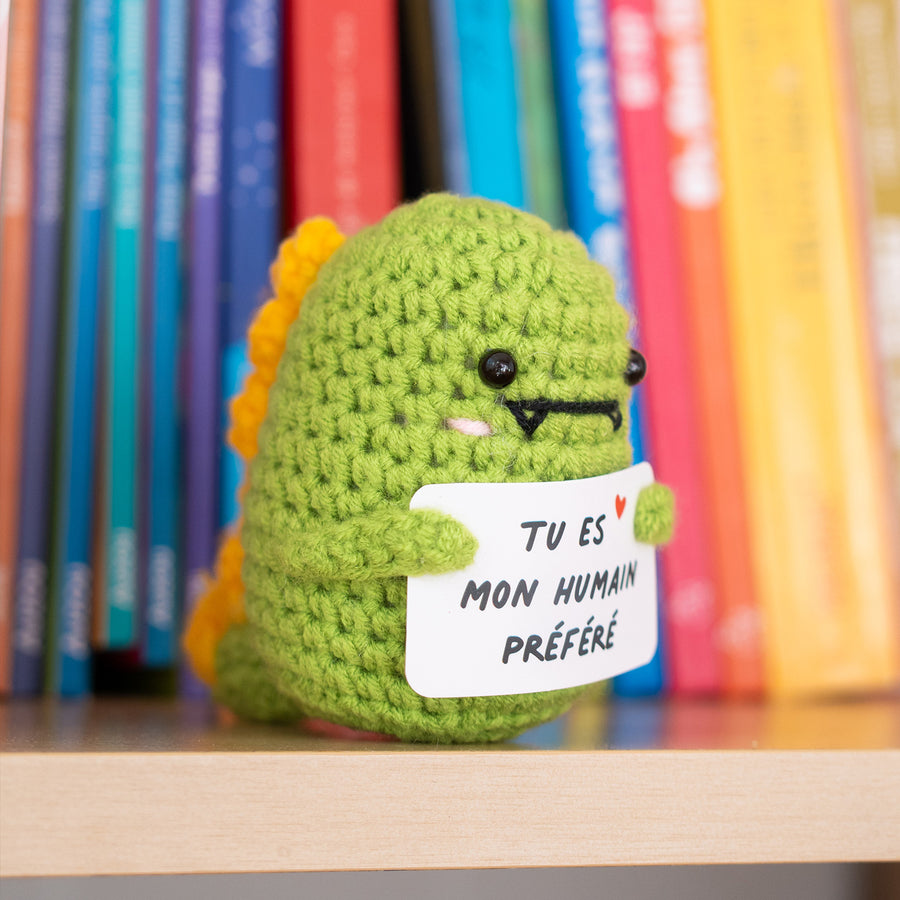 Détail du T-Rex en crochet tenant une pancarte affectueuse.