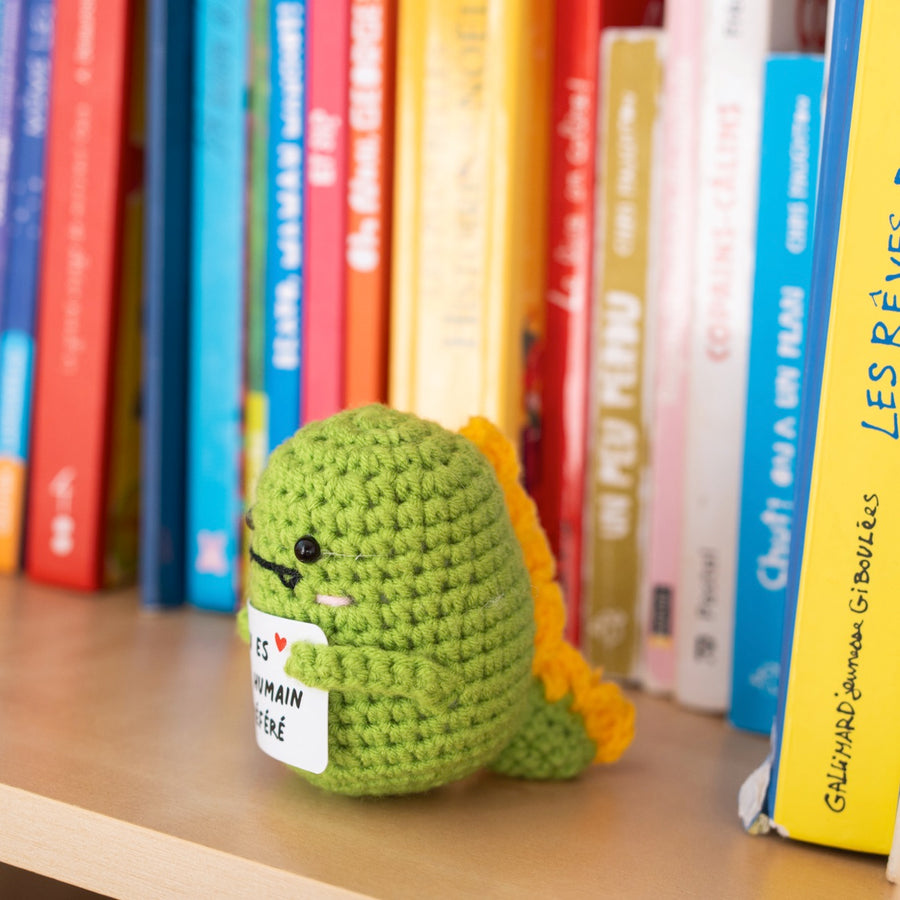 Détail du T-Rex en crochet tenant une pancarte affectueuse.