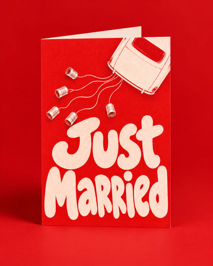 Carte « Just Married » rouge illustrée d’une voiture et de boîtes de conserve
