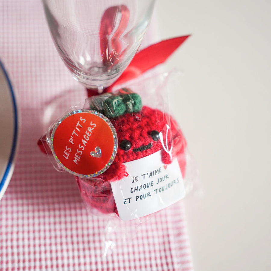 Peluche tomate en crochet avec message d'amour en gros plan.