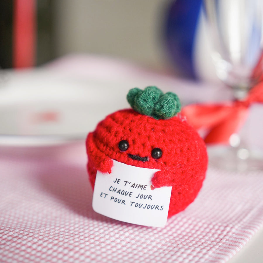 Peluche tomate en crochet avec message d'amour en gros plan.