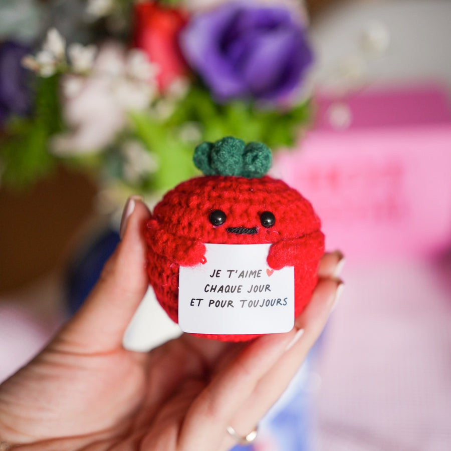 Peluche tomate en crochet avec message d'amour en gros plan.