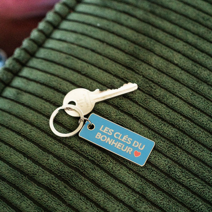 Porte-clés en métal avec inscription inspirante sur fond clair.