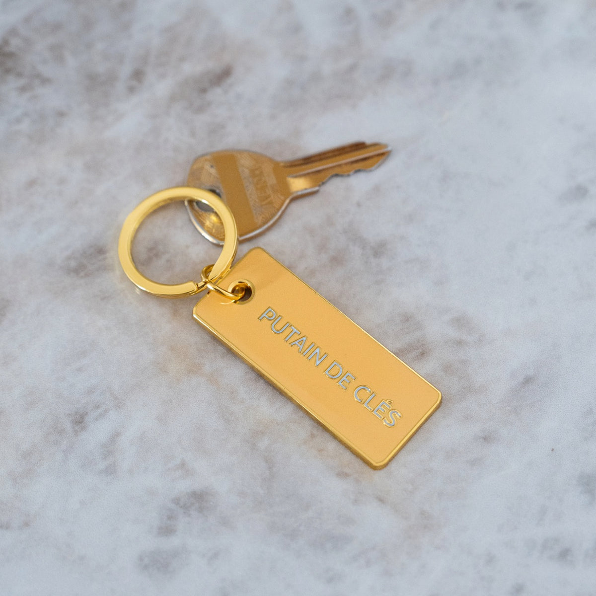 Porte-clé avec inscription humoristique sur fond neutre.