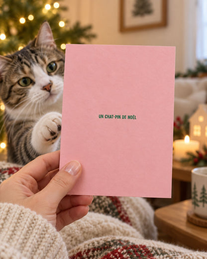 Carte de Noël avec un chat coloré sur fond festif